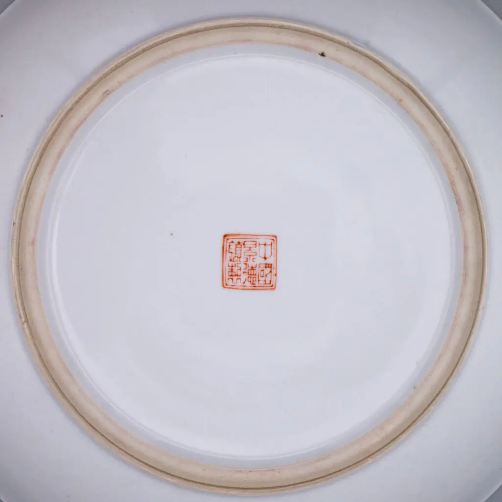 A 20th century famille rose decorated porcelain charger with bats and peaches. Stamped with a six-character China, Jingdezhen mark.